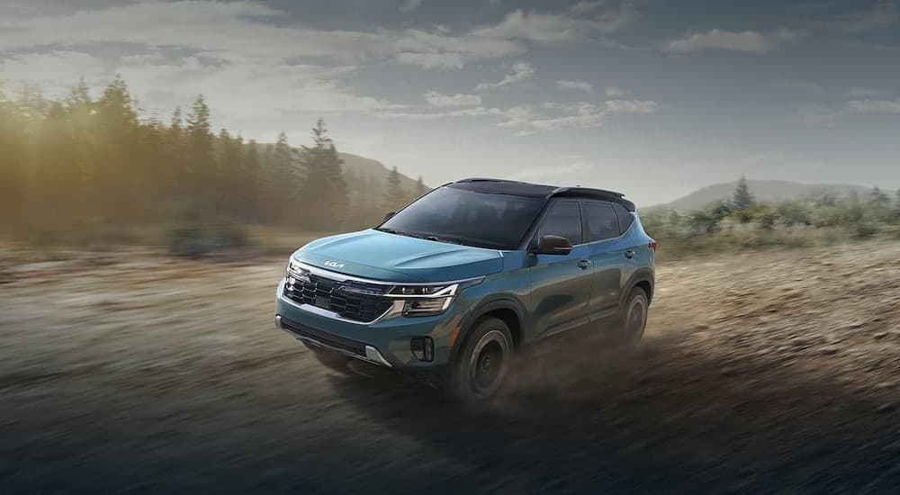 A blue 2024 Kia Seltos driving offroad.
