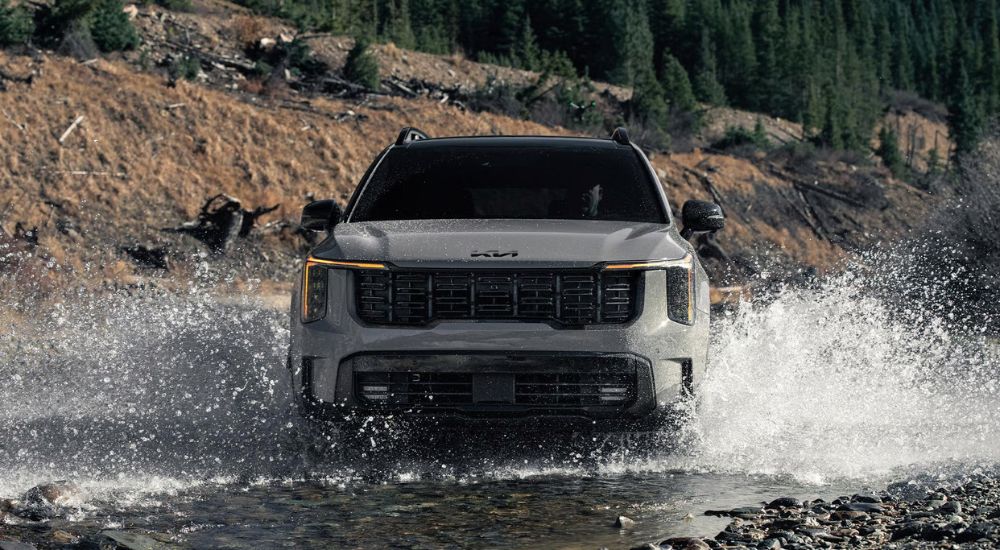 A gray 2026 Kia Sorento X-Pro SX Prestige splashing in water.