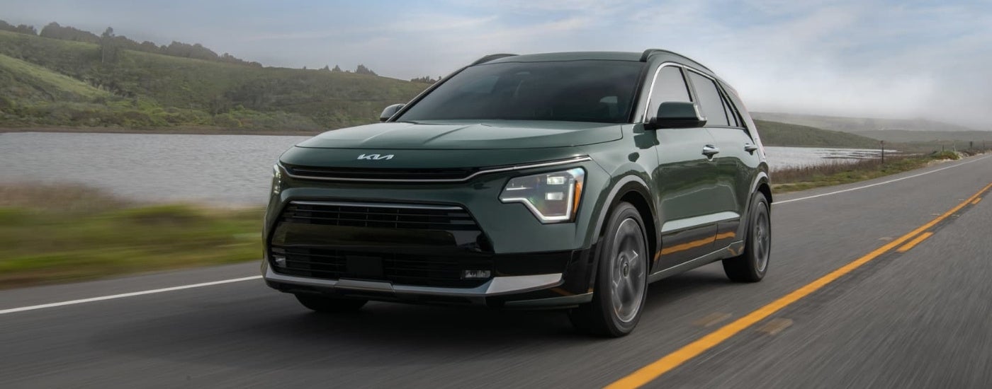 Green 2024 Kia Niro HEV driving to a Kia dealer near Maryville