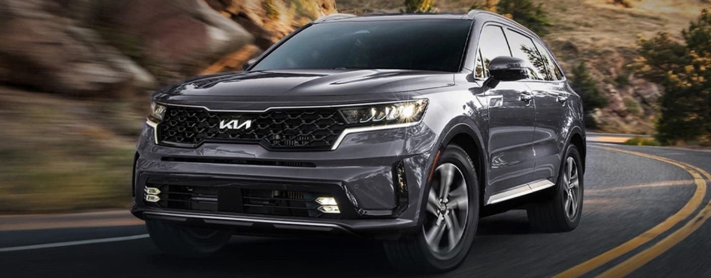 Grey 2026 Kia Sorento driving around a bend.