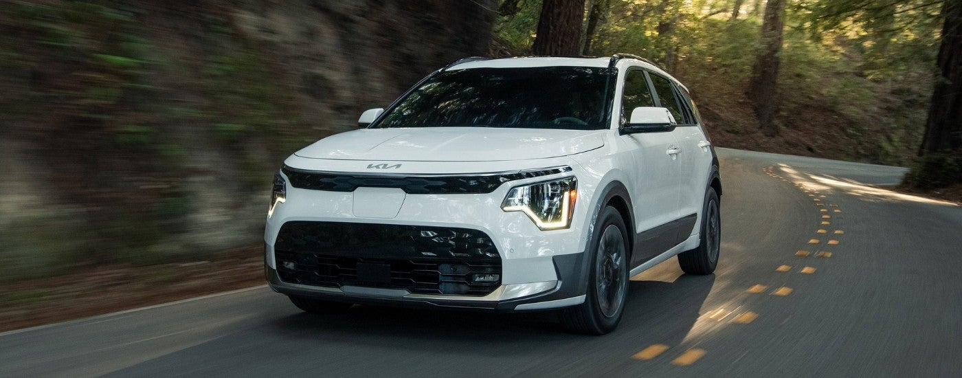 White 2025 Kia Niro EV driving to a Kia dealer near Farragut