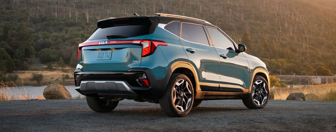 2026 Blue Kia Seltos parked near a lake at sunset.
