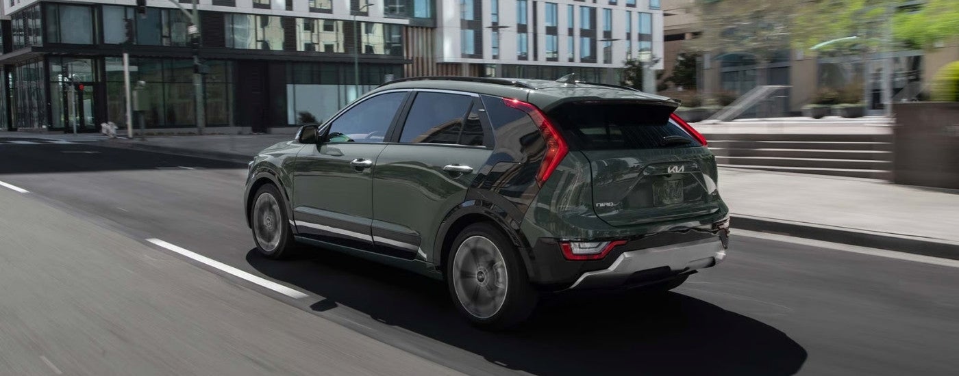 Rear view of a green 2026 Kia Niro SX Touring on a city street.