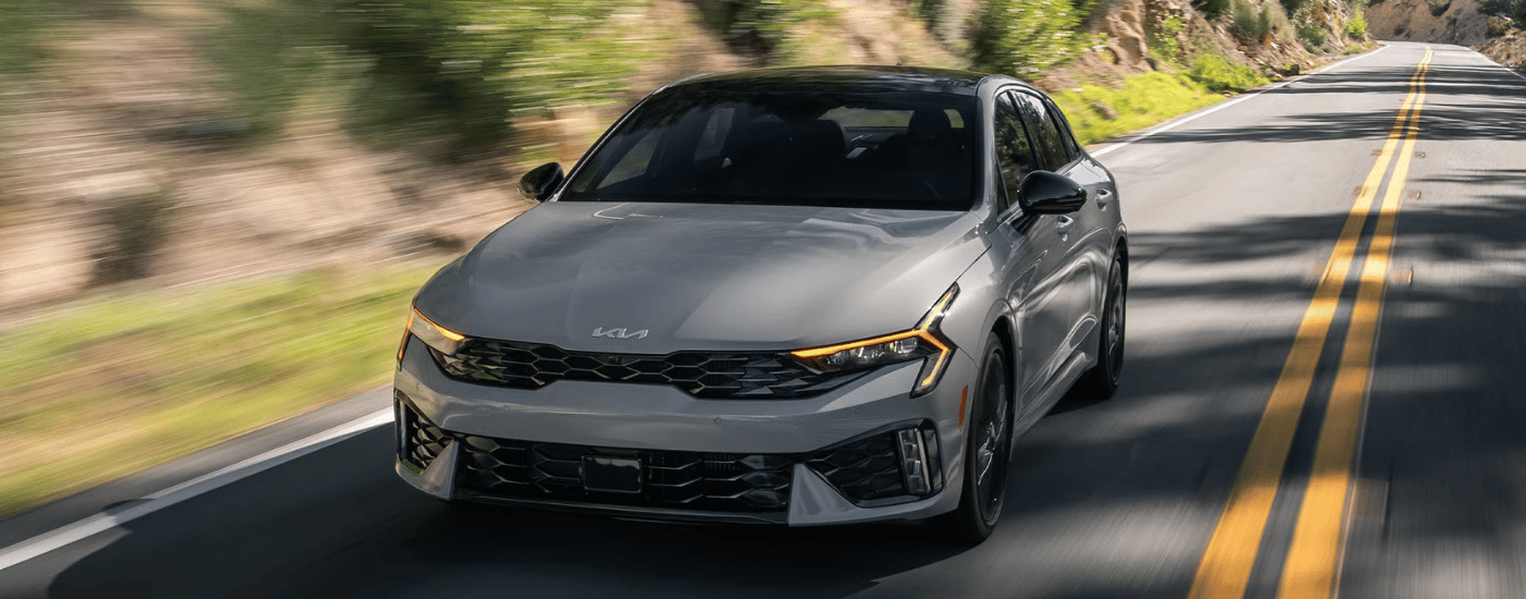 Grey 2026 Kia K5 driving along an open road