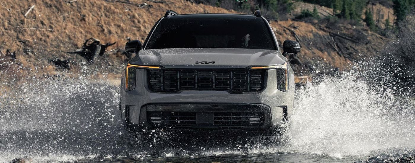 Head-on view of a gray 2026 Kia Sorento X-Pro SX Prestige splashing in water.