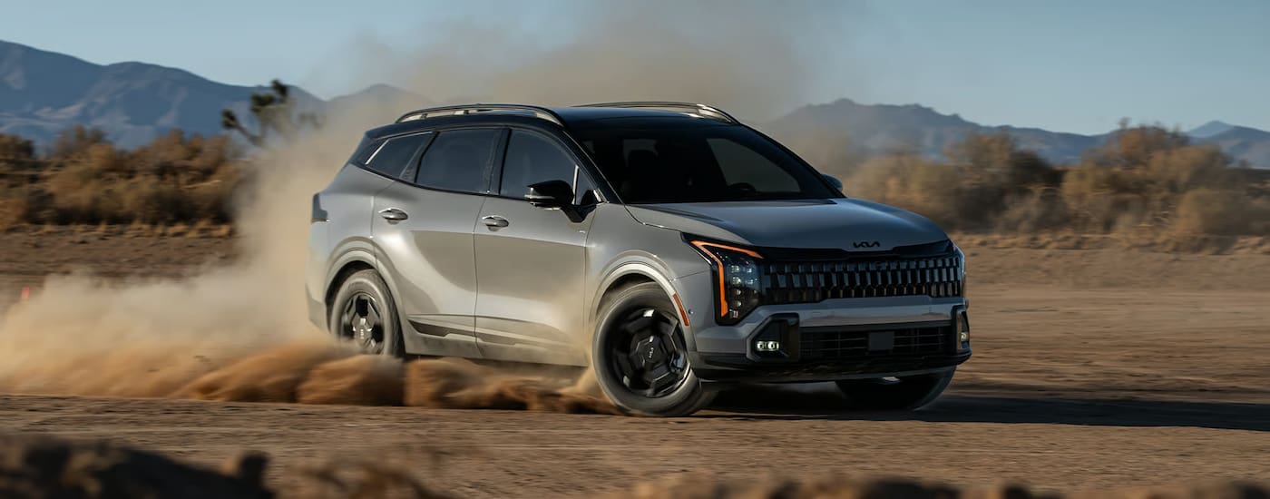 Grey 2026 Kia Sportage driving off-road.