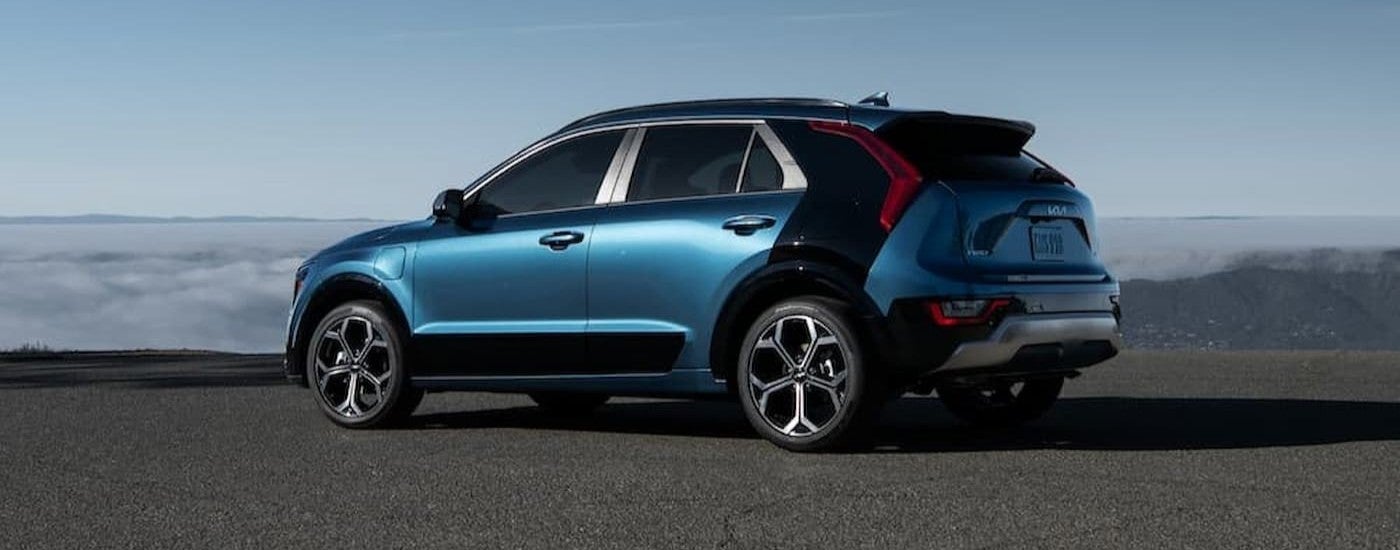 A blue 2023 Kia Niro Plug-In Hybrid parked during the day.