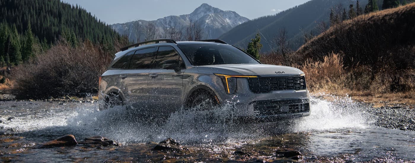 A gray 2024 Kia Sorento driving through water.